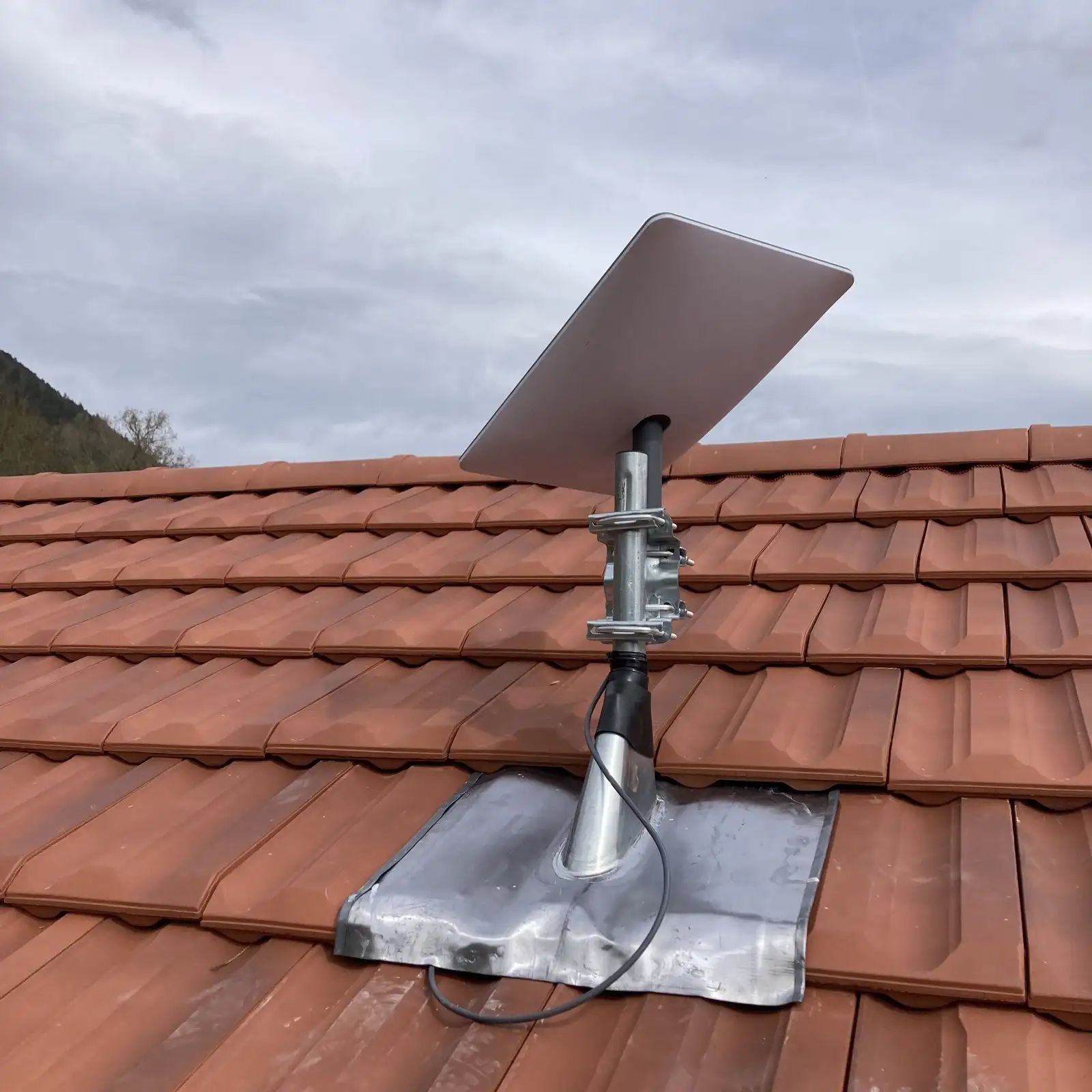 Antenne Starlink fixée sur un toit sur tuiles neuves